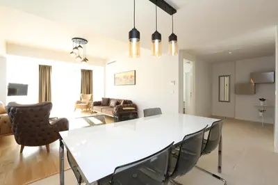 a dining room and living room with a white table and chairs at Classy Suite Taksim in Istanbul