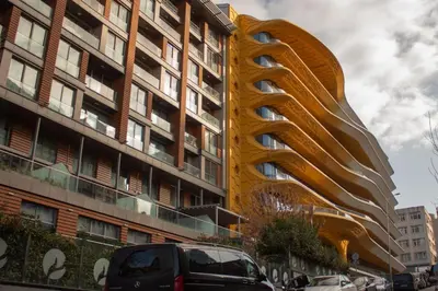 a yellow building with a curvy facade on a street at Classy Suite Taksim in Istanbul