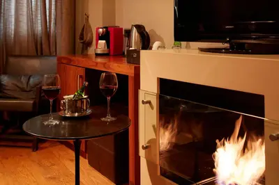 two glasses of wine on a table next to a fireplace at Taksim Prelude Hotel in Istanbul