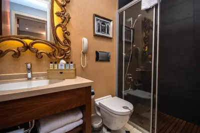 a bathroom with a toilet and a sink and a mirror at The Story Hotel Pera in Istanbul