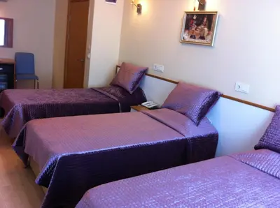 three beds in a room with purple covers at Hotel Avcilar City in Avcılar