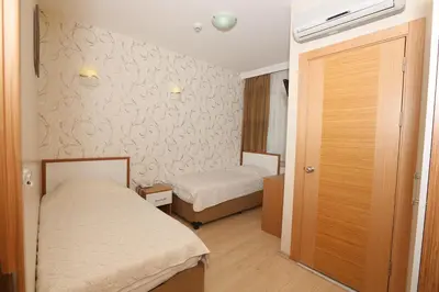 a small room with two beds and a door at Hotel Avcilar City in Avcılar