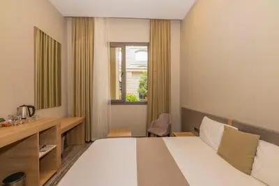 a hotel room with a bed and a desk at Agora Suites in Esenyurt