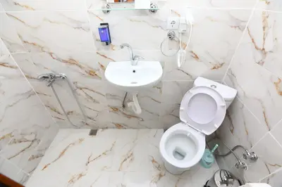 a white bathroom with a toilet and a sink at Yeni Hotel in Istanbul