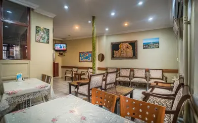 a restaurant with tables and chairs and a tv at Yeni Hotel in Istanbul