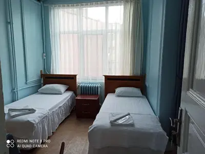 two beds in a blue room with a window at Yeni Hotel in Istanbul