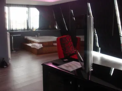 a bathroom with a sink and a desk with a red chair at Golden Palas Hotel in Cerkezkoy
