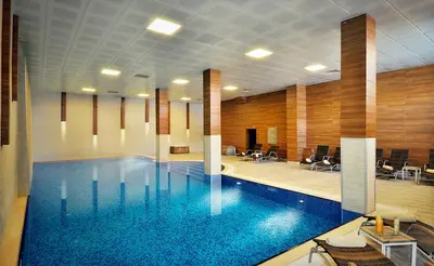 a large swimming pool in a large room with chairs at Kaya Uludag in Uludag