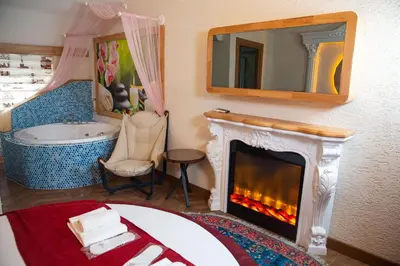 a bedroom with a fireplace and a tub and a mirror at Emirtimes Hotel Kadıköy in Istanbul