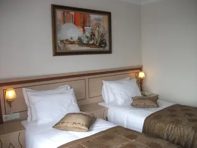 a hotel room with two beds and a picture on the wall at Sultan Palace Hotel in Istanbul