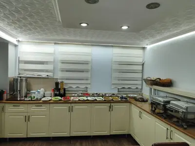 a kitchen with white cabinets and a counter with food at Hotel Ay in Istanbul
