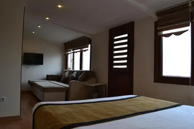 a bedroom with a bed and a living room with a couch at Seven Days Hotel - İstanbul in Istanbul