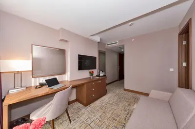 a hotel room with a desk with a laptop and a television at Land Park Hotel in Istanbul