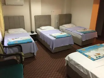 a room with three beds in a room at Paris Hotel in Istanbul