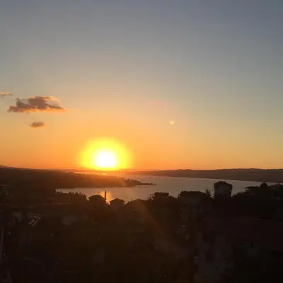 a sunset with the sun setting over the water at Yıldız Pansiyon in Sapanca