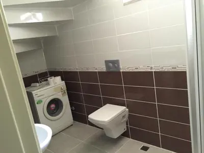 a bathroom with a toilet and a washing machine at Yıldız Pansiyon in Sapanca