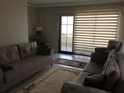 a living room with a couch and a large window at Yıldız Pansiyon in Sapanca