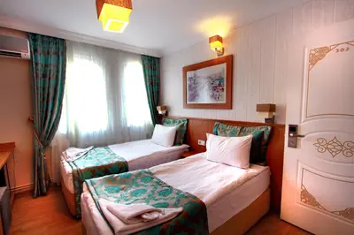 a hotel room with two beds and a window at Agora Boutique Hotel & Bistro in Istanbul