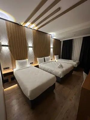a hotel room with two beds and two tables at Rays Hotel - Bakirkoy Istanbul City Center in Istanbul