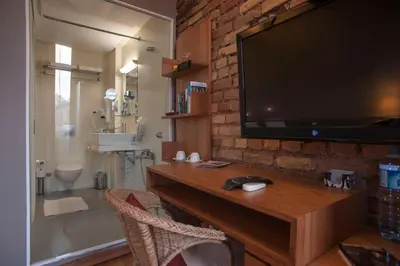 a bathroom with a tv on a brick wall at Peradays in Istanbul