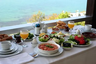 a breakfast table with food and drinks on a balcony at Erzurumlu Hotel in Kilyos