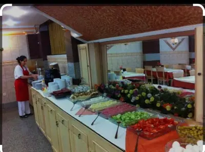 a woman standing in a kitchen with a counter full of food at Grand Dilara Hotel in Istanbul