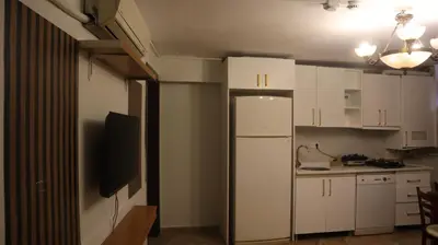 a kitchen with white cabinets and a white refrigerator at Blue Eye Suites in Istanbul