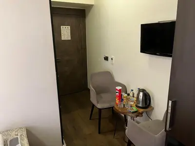 a room with a table and a chair and a television at Pandora Hotel in Istanbul