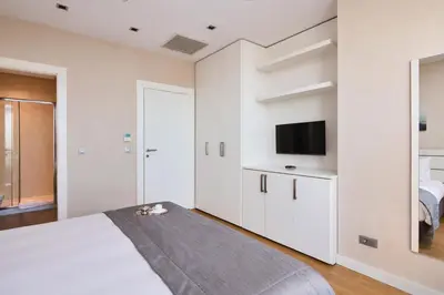 a white bedroom with a bed and a tv at Fraser Place Anthill Istanbul in Istanbul