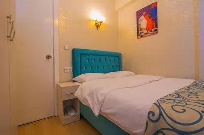 a small bedroom with a bed with a blue headboard at Ancient Town Hotel in Istanbul