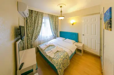 a bedroom with a bed with a blue headboard and a window at Ancient Town Hotel in Istanbul
