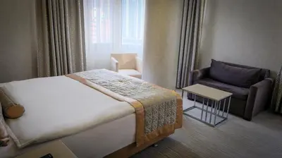 a hotel room with a bed and a chair at Kervansaray Bursa City Hotel in Bursa