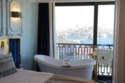 a bedroom with a tub and a balcony with a view at Golden Horn Bosphorus Hotel in Istanbul