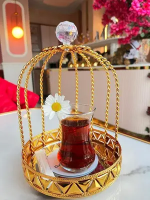 a glass of tea in a gold basket with a flower at Golden Horn Bosphorus Hotel in Istanbul