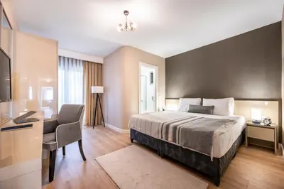 a bedroom with a bed and a desk and a chair at Çırağan Apart Bosphorus in Istanbul