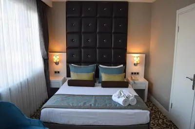 a bedroom with a large bed with a large headboard at Taksim Line Hotel in Istanbul