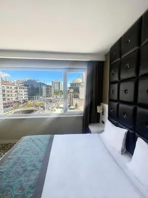 a hotel room with a large bed and a large window at Taksim Line Hotel in Istanbul