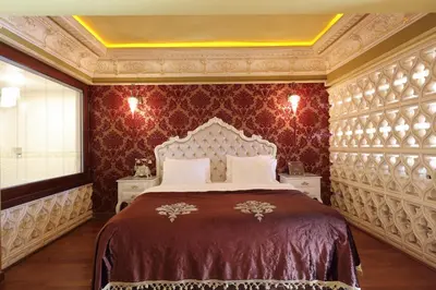 a bedroom with a large bed with red wallpaper at Deluxe Golden Horn Sultanahmet Hotel in Istanbul