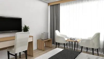 a living room with a television and white chairs at Kutlucan Oldtown in Bursa