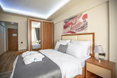 a bedroom with a large bed with white sheets and pillows at Kutlucan Oldtown in Bursa