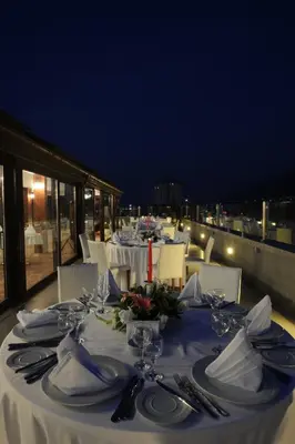 a group of tables with plates and utensils on a balcony at Burcman Hotel in Bursa