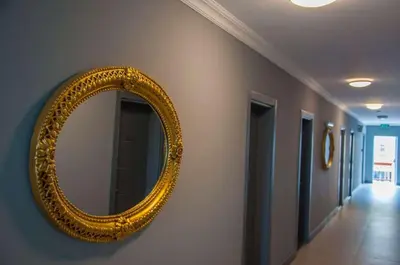a gold mirror on a wall in a hallway at Room Room Motel in Sapanca