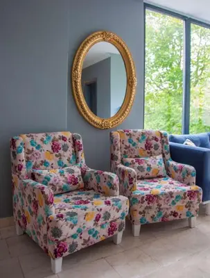 a living room with a chair and a mirror at Room Room Motel in Sapanca