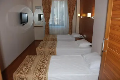 a row of four beds in a hotel room at The Port Hotel in Istanbul