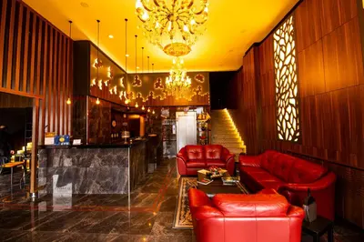 a lobby with red leather furniture and a chandelier at Classes Hotel Airport in Istanbul