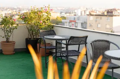 a table and chairs on a balcony with plants at Classes Hotel Airport in Istanbul