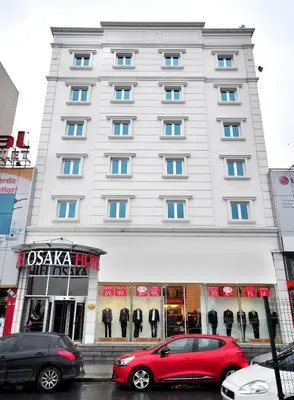 a large white building with cars parked in front of it at Hotel Osaka Airport in Istanbul