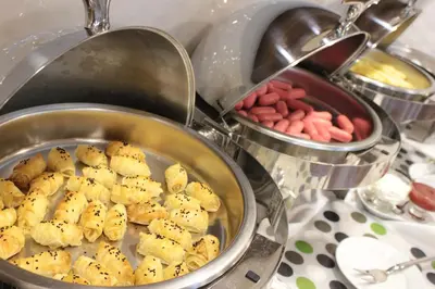 a pan filled with food next to other pans of food at Hotel Osaka Airport in Istanbul