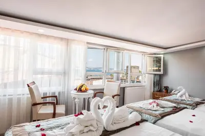 a bedroom with two beds and a table with chairs at Istanbul Sirkeci Hotel in Istanbul