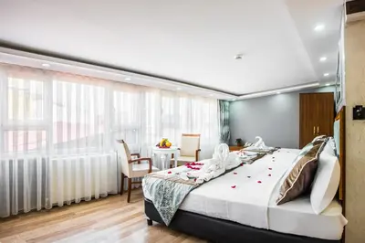 a bedroom with a large bed and a dining room at Istanbul Sirkeci Hotel in Istanbul